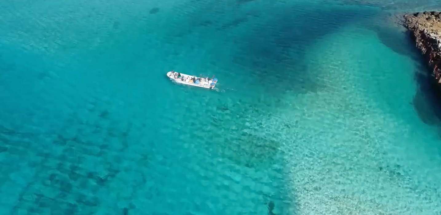 沖縄の海とボートをドローンで空撮